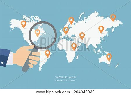 Hand holding magnifying glass on world map.