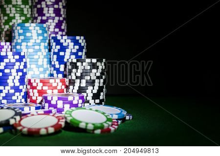 Stack of Poker chips on a green gaming poker table at the casino. Poker game concept. Playing a game with dice. Casino Concept for business risk chance good luck or gambling. chips for poker game