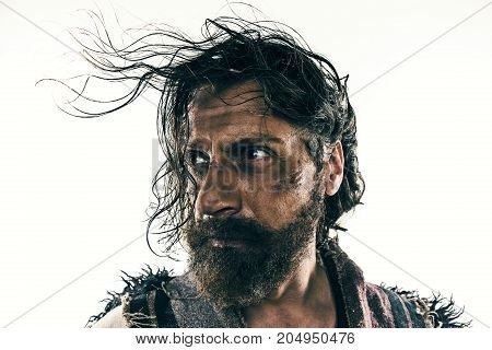 Portrait of a brutal bald-headed viking in a battle isolated against a white background. Early medieval period. Actor in makeup. concept of vagrancy and survival