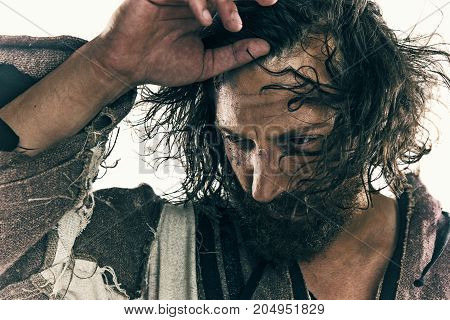 Portrait of a brutal bald-headed viking in a battle isolated against a white background. Early medieval period. Actor in makeup. concept of vagrancy and survival