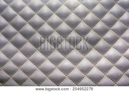 Grey quilted leather. Stylish background pattern. Threads.