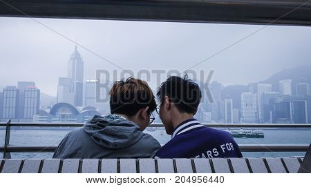People Sitting On Embankment In Hong Kong.