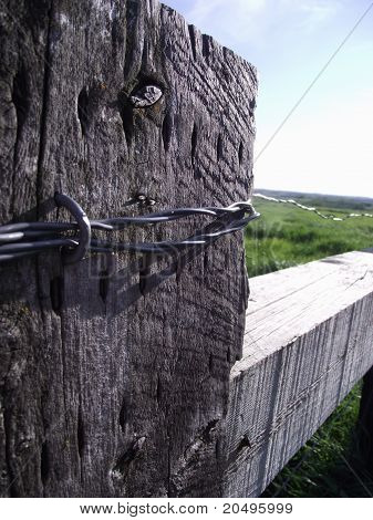 Poste de la cerca con alambre de púas en perspectiva