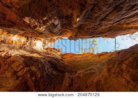 Crevice in the red loamy wall of Providence Canyon bottom view in sunny day USA