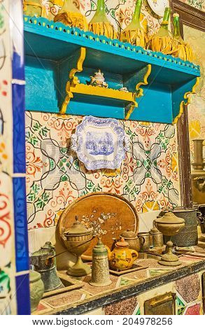 SOUSSE TUNISIA - SEPTEMBER 3 2015: The kitchen of Dar Essid mansion with vintage tableware wooden shelves and glazed tile on walls on September 3 in Sousse.