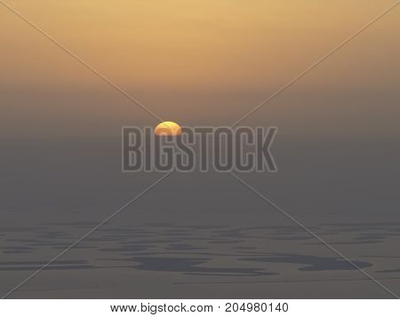 A setting sun at sea shore from 125th floor at Dubai