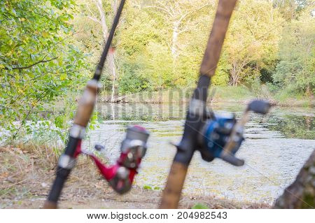 Blurred Front Background. Two fishing rods with reels. One reel spinning and second baitcasting reel