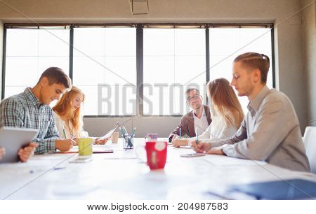 Team at work concept. Group of young business people in smart casual wear working together in creative office.