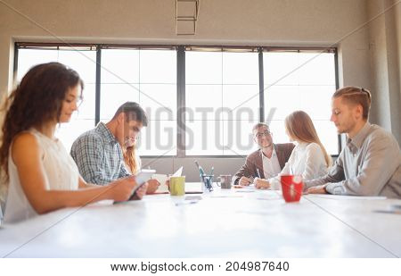 Team at work concept. Group of young business people in smart casual wear working together in creative office.