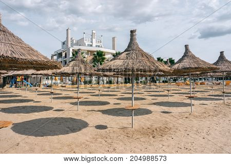 ALBANIA GOLEM- September 21 2015: Sandy beach on the Adriatic Sea umbrellas from the sun with thatched roofs.