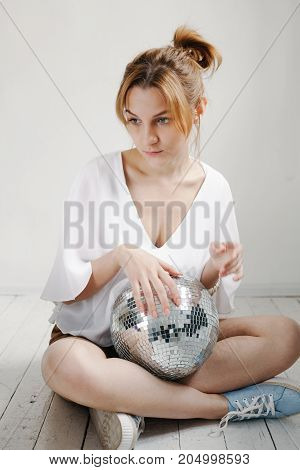 Young Hipster Woman Holding Disco Ball And Posing Cheerfully On White Background