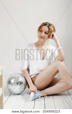 Young Hipster Woman Holding Disco Ball And Posing Cheerfully On White Background