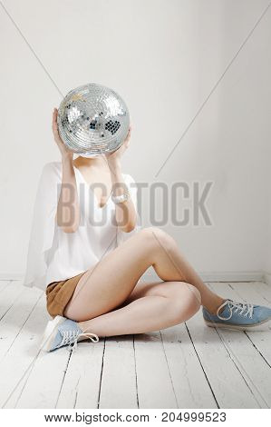 Young Hipster Woman Holding Disco Ball And Posing Cheerfully On White Background