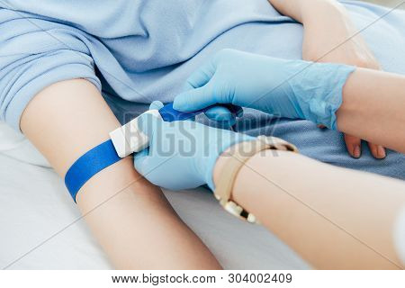 Partial View Of Doctor Using Tourniquet For Blood Test In Hospital