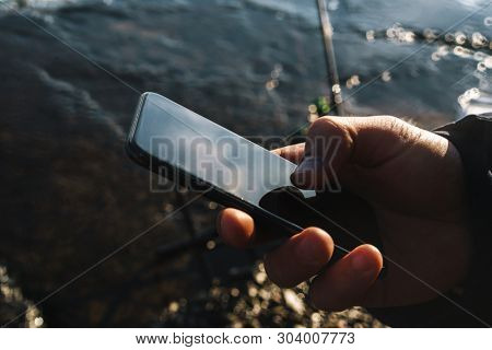 Cropped image of a handsome man fisherman at the seashore.