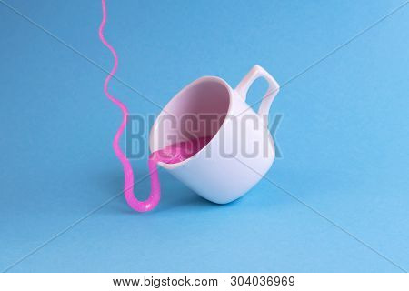 Bright Pink Glitter Slime Comes In Mug. White Cup On Blue Background. Art Neon Surrealism And Minima
