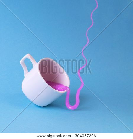 Bright Pink Glitter Slime Comes In Mug. White Cup On Blue Background. Art Neon Surrealism And Minima