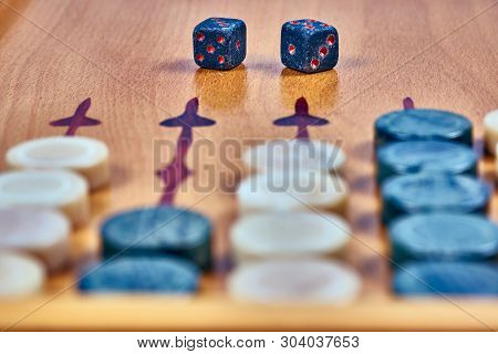 Backgammon Game. Game Dice Made Of Stone Lie On The Backgammon Board Against The Background Of Check