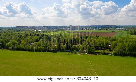 Top View Of A Plot Of Agricultural Field And A City In The Distance