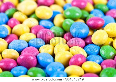 Pile of delicious ainbow colorful chocolate candies background. Macro image.