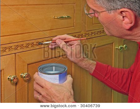 Man lakken decoratieve versiering op een entertainment center