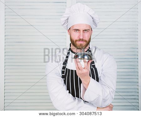 Man Cook Hat And Apron Hold Meal Covered With Lid. Delicious Meal Presentation. Haute Cuisine Charac