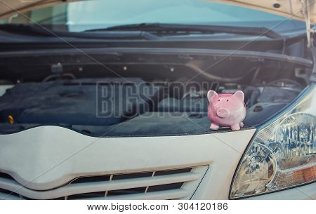Pink Piggy Money Box On The Opened Hood Of A Broken Car. Financial Credit For Transportation Repair 