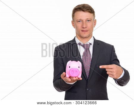 Studio Shot Of Young Handsome Caucasian Businessman Holding Pigg
