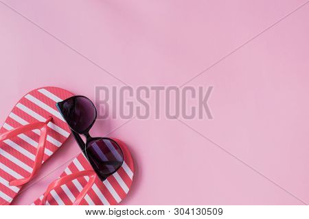Flip Flops And Sunglasses On A Pink Background. Top View, Flat Lay