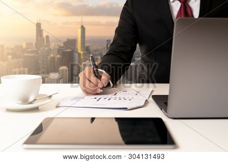 Hand's Businessman Holding Pen And Analysis Data Chart On Document Paper And Looking Computer At Mod