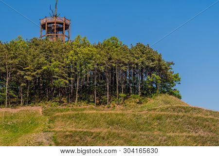 Wooden Observation Tower In Center Of Grove Of Trees On Top Of Manicured Hill.