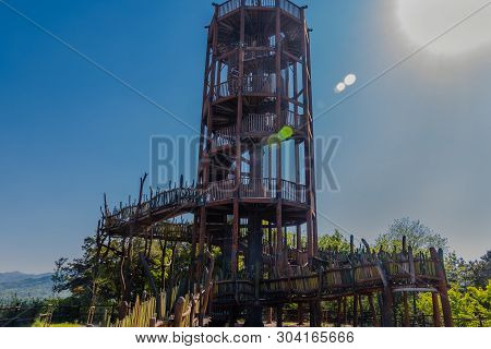 Wooden Observation Tower With Winding Staircase On Top Of Mountain On Sunny Day With Blue Sky.