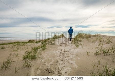 Lone Man In Blue Walks Along The Sand Dunes At Diamond Beach In Spring, Wildwood Crest, Nj