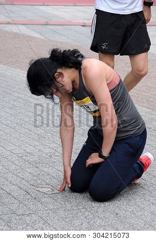 Plovdiv, Bulgaria - May 5, 2019:  Unidentified Female Half-marathon Runner Is On Her Knees Exhausted