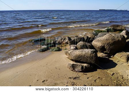 Big Stones On The Beach Of Rybinsk Reservoir. Summer Seascape With Ripple Waters And Bowlders. Yaros
