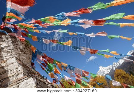 Colorful Tibetan Flags And Snow Mountain At Siguniang Scenic Area In Autumn Season,chengdu, China.