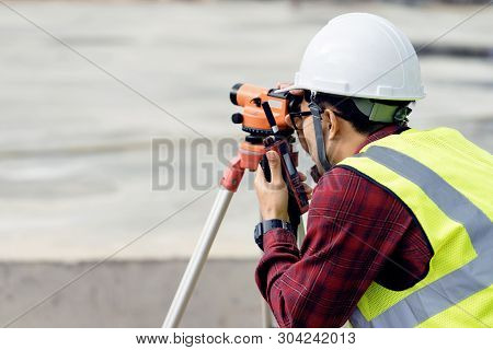 Surveyor Engineer With Theodolite At Construction Site During Surveying Work.engineer And Architect 