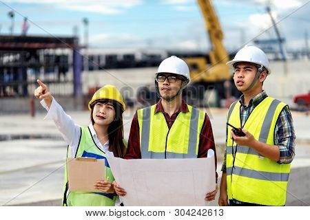 Foreman 3 People Are Held A Blueprint To Discuss The Construction Structure.woman Engineers Wear Saf