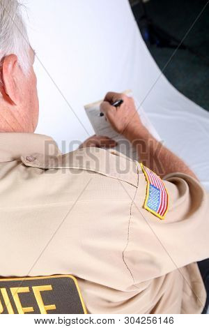 Police man writing a ticket. Police officer issuing a speeding or traffic ticket. Isolated on white. Room for text. 