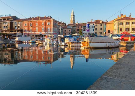 Izola, Slovenia - May 1, 2019: Scenic Harbour With Boats And Brightly Coloured Houses On The Sunset 