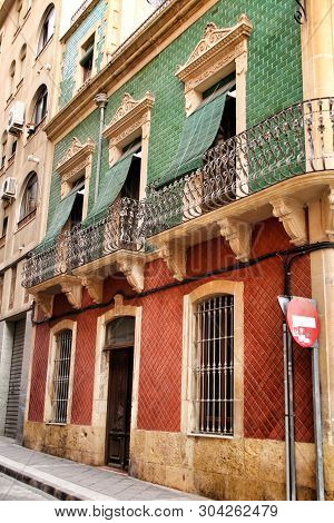 Old Colorful And Majestic Tiled Facades With Vintage Streetlight In Elche, Alicante, Spain. El Raval