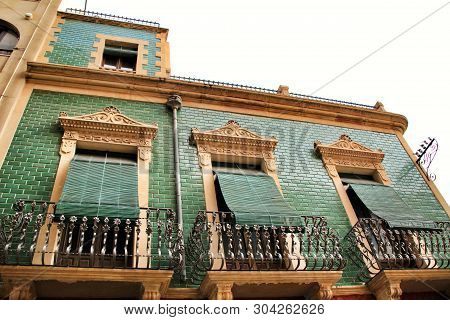 Old Colorful And Majestic Tiled Facades With Vintage Streetlight In Elche, Alicante, Spain. El Raval