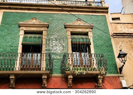 Old Colorful And Majestic Tiled Facades With Vintage Streetlight In Elche, Alicante, Spain. El Raval