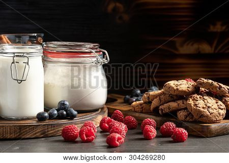 Raspberries, Blueberries And Homemade Cookies Placed On Wooden Platters