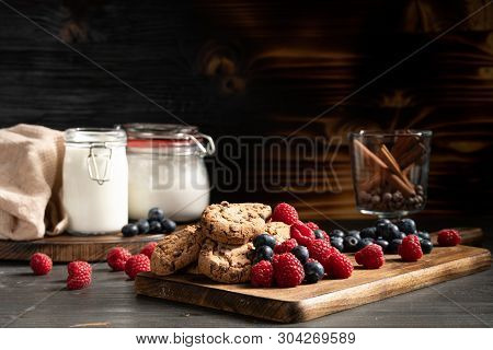 Chocolate Cookies Next To Blueberries And Rasberry