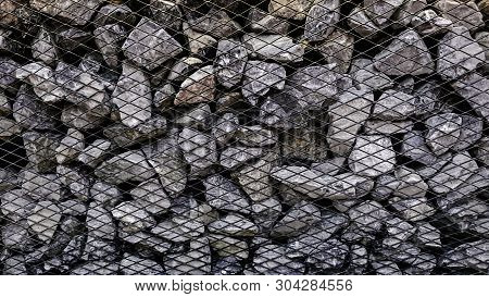 Limestone Rock Stack Background, Rock Stack With Net Barrier, Abstact Background Of Stone To Be Bloc