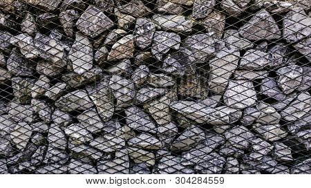 Limestone Rock Stack Background, Rock Stack With Net Barrier, Abstact Background Of Stone To Be Bloc