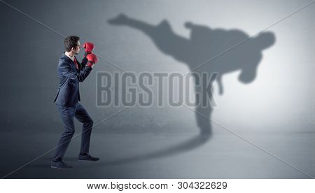 Businessman fighting with his strong karate man shadow
