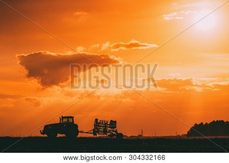 Tractor Rides On Countryside Road. Beginning Of Agricultural Spring Season. Cultivator Pulled By A T