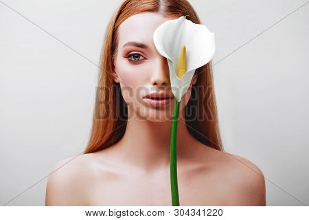 Portrait Of Happy Young Redhead Lady Looking Out Of White Flowers Studio Shot